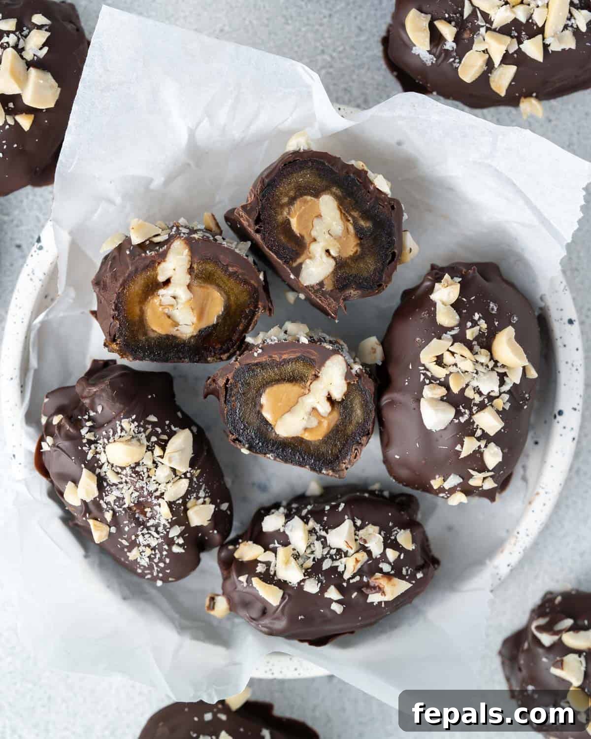 A close-up overhead shot of sliced date Snickers showing peanut butter and pecan filling inside the chocolate coating.