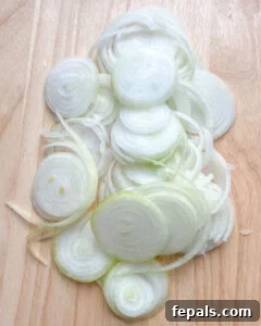 Golden Crunch Onion Rings 12 sliced onions on a cutting board.