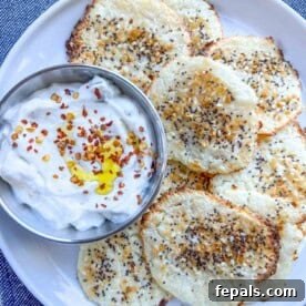 Crispy Cottage Cheese Bites 10 cottage cheese chips on a plate next to a small bowl with white dipping sauce.