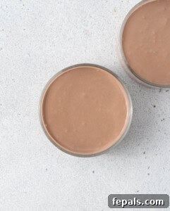 Two mousse-filled cups without toppings, smooth and creamy chocolate layer visible.