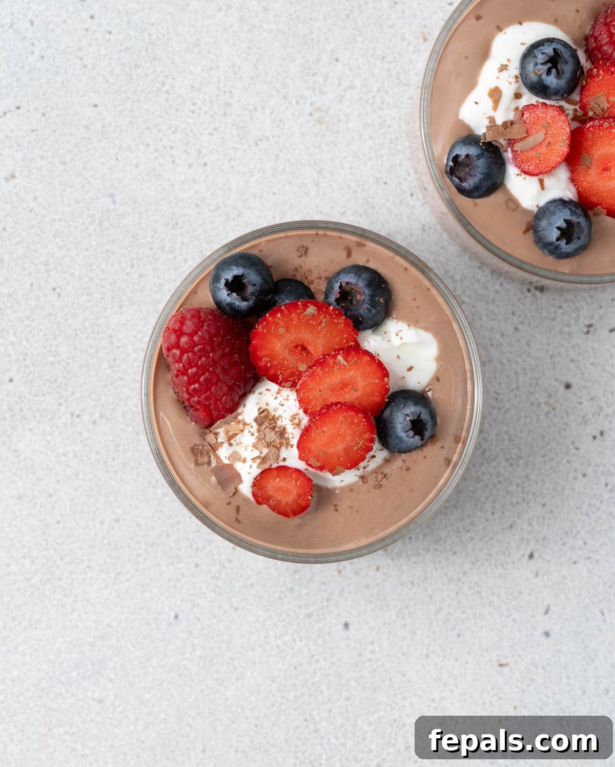 Two small bowls of chocolate on a white surface