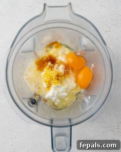 Eggs, cottage cheese, vanilla extract, oil, lemon zest, and lemon juice added into a blender cup.