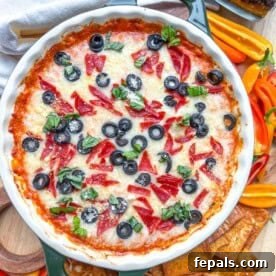 Crustless Pizza Cottage Bowl 12 a round dish with baked crustless pizza made with cottage cheese, topped with black olives, pepperoni, and sliced basil.