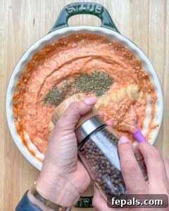Crustless Pizza Cottage Bowl 14 Hand adding cracked black pepper over the cottage cheese and marinara sauce.