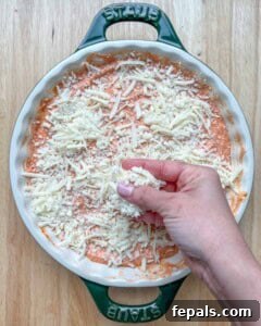 Crustless Pizza Cottage Bowl 15 Hand topping the cottage cheese and marinara sauce in a round dish.
