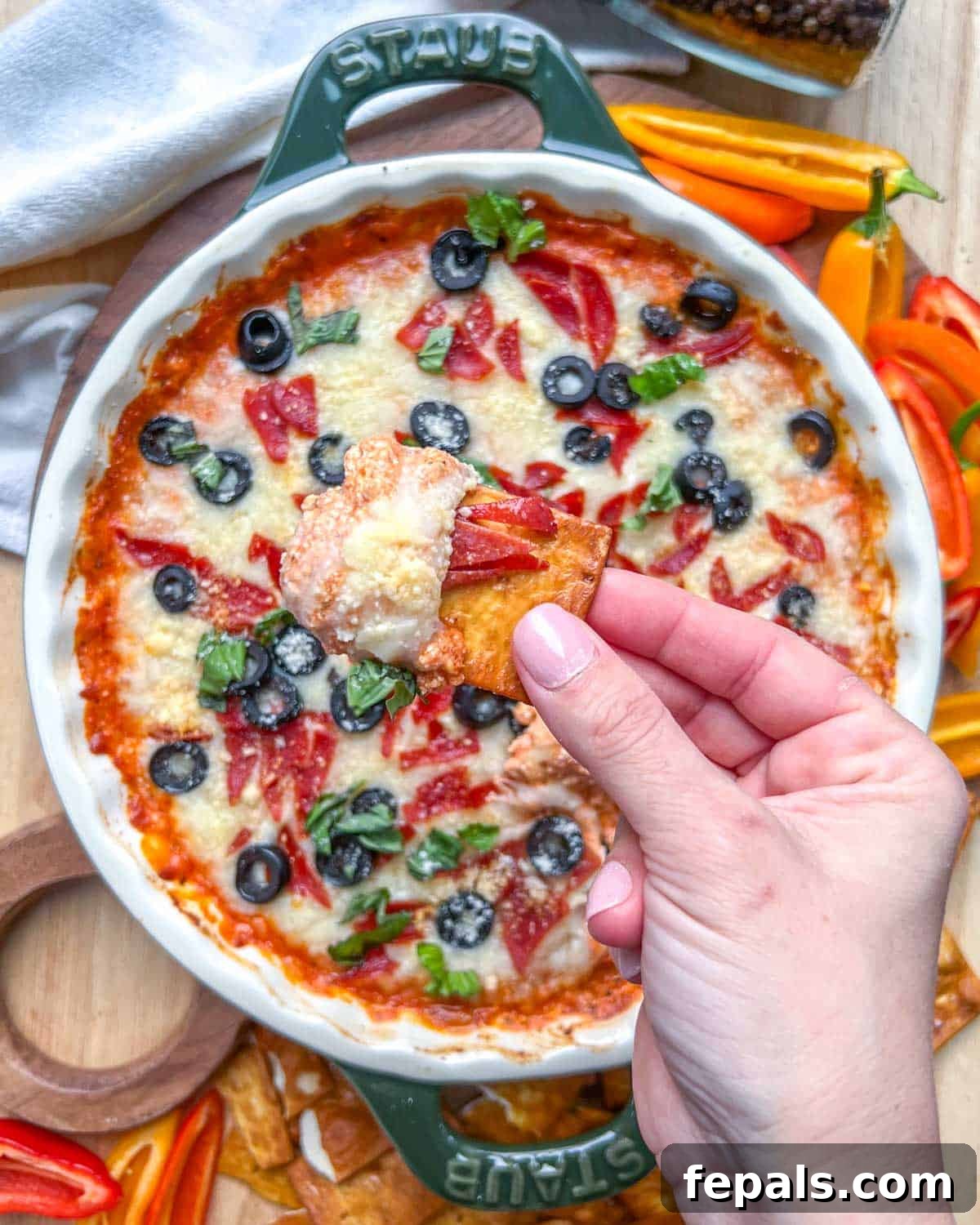Crustless Pizza Cottage Bowl 7 hand holding a chip with a portion of the cottage cheese pizza.