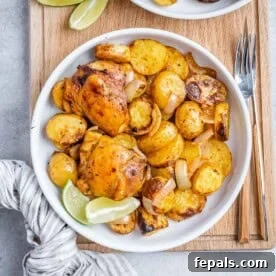 Overhead shot of a bowl filled with juicy chicken thighs and crispy roasted baby potatoes, ready to be served.