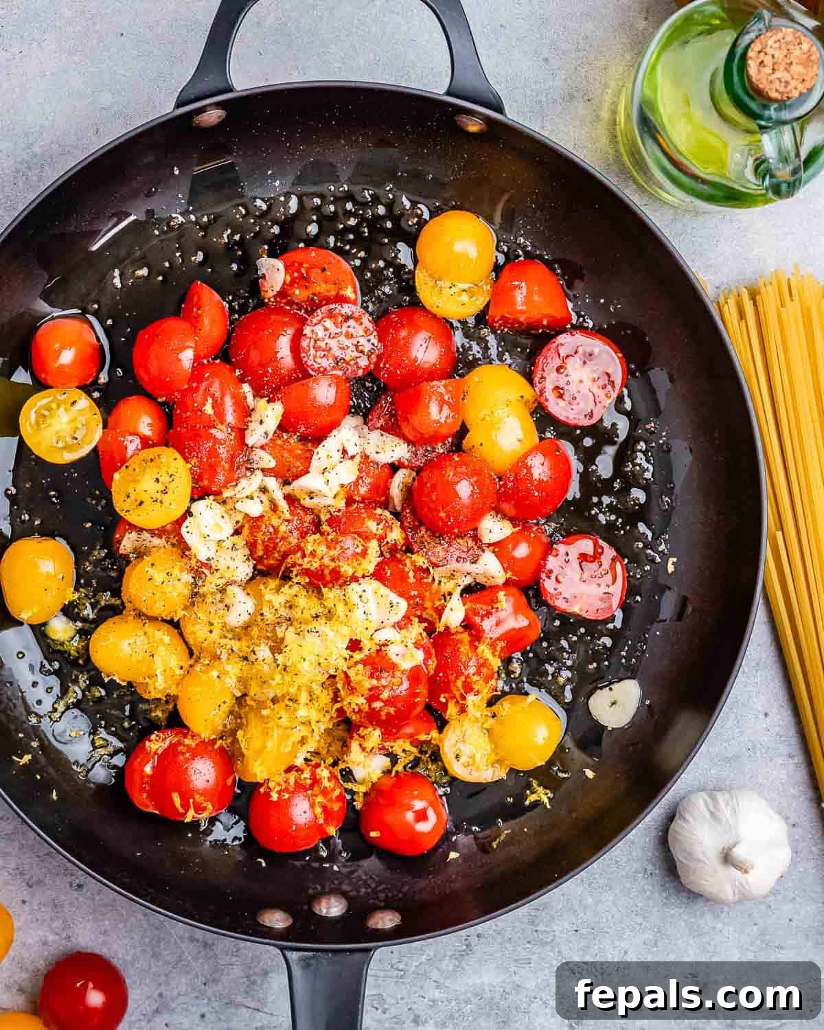 sliced tomatoes in a skillet with garlic and oil.