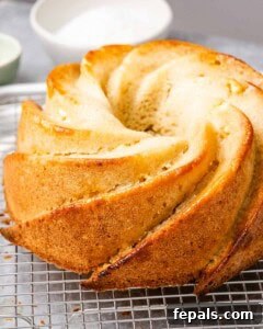 Tropical Coconut Bliss Cake 18 Bare golden-brown bundt cake resting on a wire rack, just out of the oven and not yet frosted.