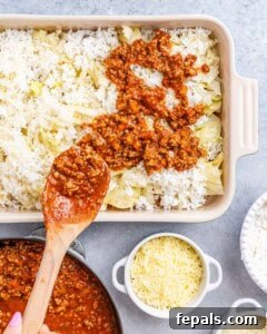 Easy Cabbage Roll Bake 12 Layering the casserole: chopped cabbage, then rice, Parmesan cheese, and finally, the beef and marinara sauce, neatly arranged in a baking dish.