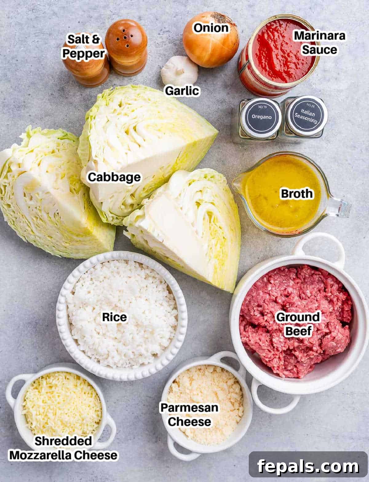 Easy Cabbage Roll Bake 3 A collection of fresh ingredients laid out on a wooden board, including a head of green cabbage, a bowl of ground beef, a jar of marinara sauce, fresh garlic, an onion, and small bowls of dried oregano and Italian seasoning, ready for making Cabbage Roll Casserole.