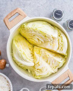 Easy Cabbage Roll Bake 9 Cabbage halves boiling in a pot of water, a crucial step for achieving tender cabbage in the casserole.