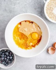 Soft-Baked Blueberry Oatmeal Cookies 15 egg, tahini, and honey, added over mashed bananas in a bowl.