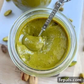 Handcrafted Pistachio Perfection 9 Pistachio butter in a jar with a spoon in the jar.