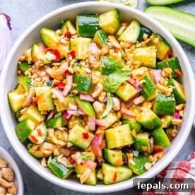 a round white bowl with cucumber salad with Thai dressing.