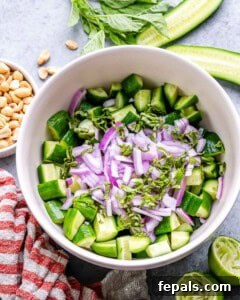 chopped cucumber in a bowl with red onion and basil