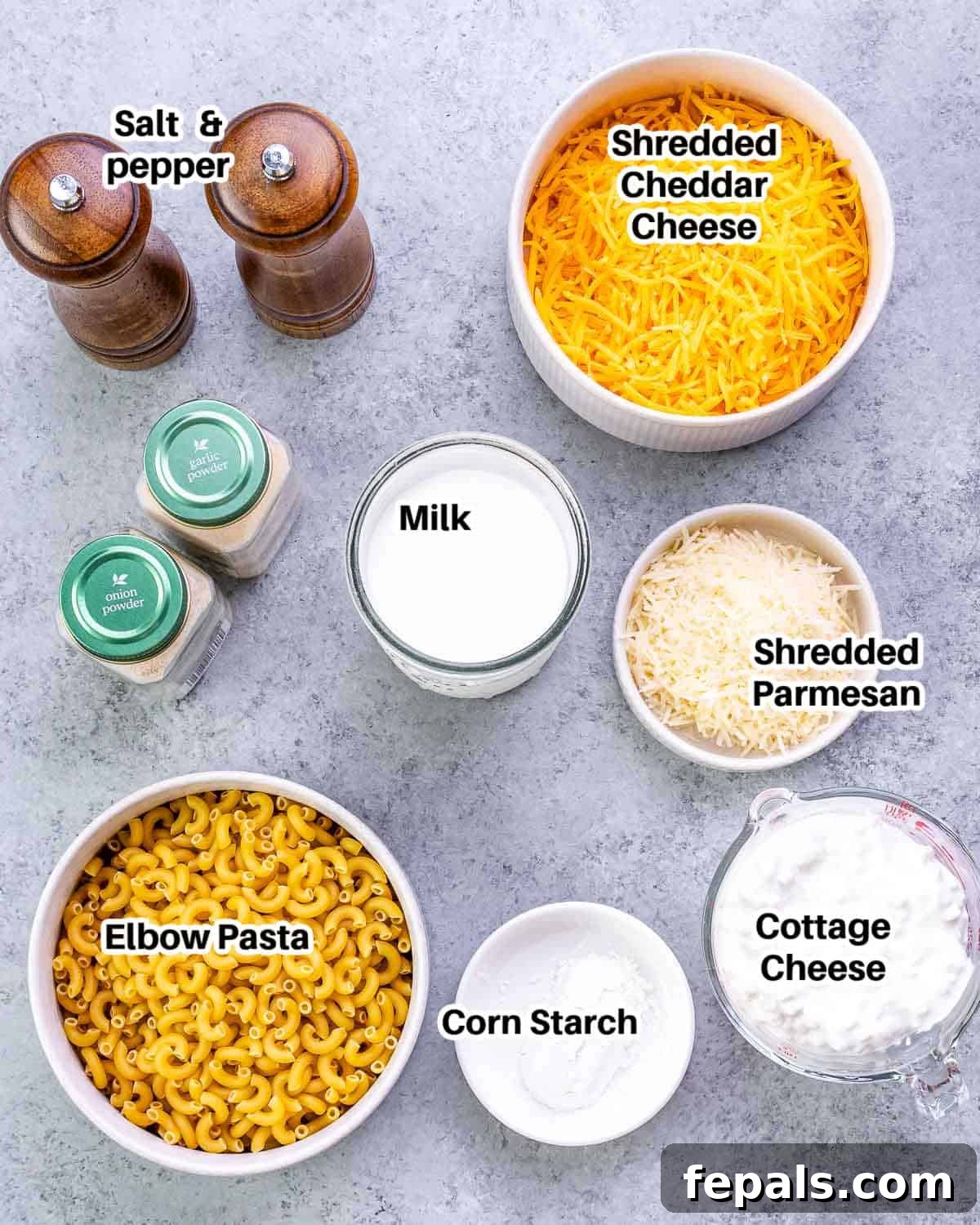 Velvet Cottage Mac and Cheese 3 Various ingredients laid out for making cottage cheese mac and cheese: pasta, cheeses, milk, cottage cheese, and seasonings.
