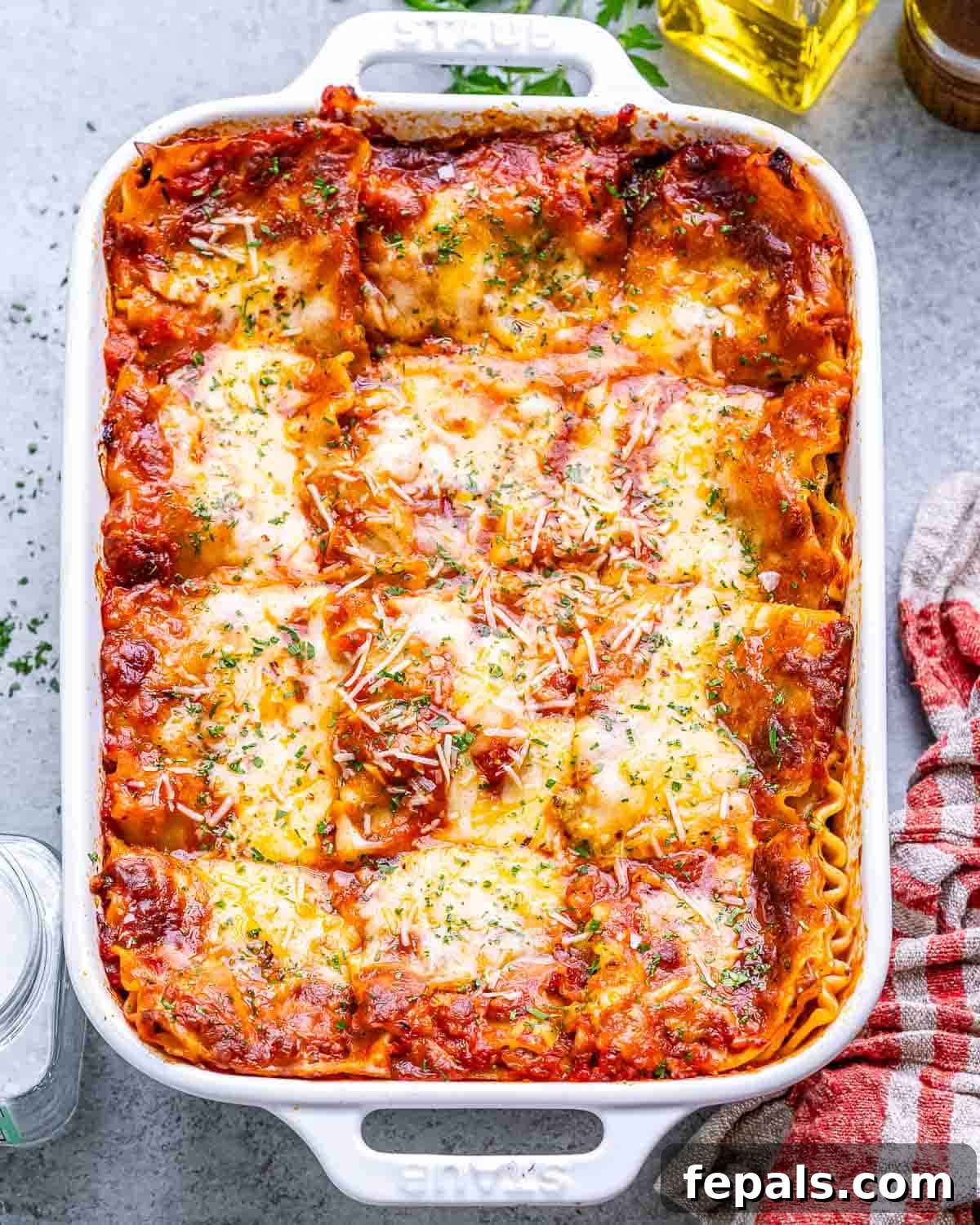 Homestyle Cottage Cheese Lasagna 6 A freshly baked Cottage Cheese Lasagna in a white baking dish, still warm from the oven, with a golden, bubbly cheese topping and vibrant green hints of spinach.
