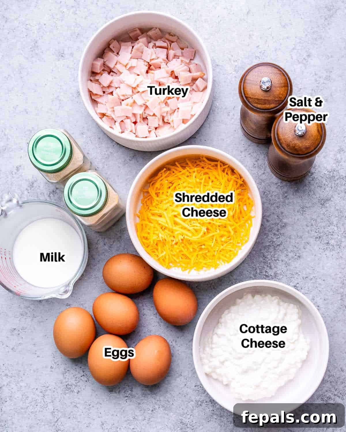 Protein-Packed Cottage Cheese Egg Cups 3 A collection of fresh ingredients laid out for making cottage cheese egg bites, including eggs, cheese, cottage cheese, and turkey deli meat.