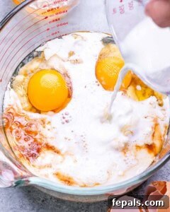 Wet ingredients for banana cottage cheese pancakes being whisked.