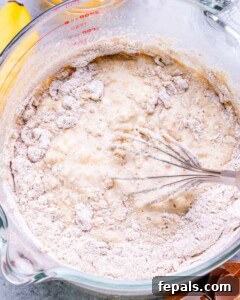 Oat flour mixture being added to the wet pancake batter ingredients.