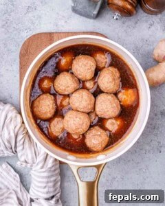 Sticky Teriyaki Turkey Meatballs 12 Meatballs coated in teriyaki sauce in a pot.