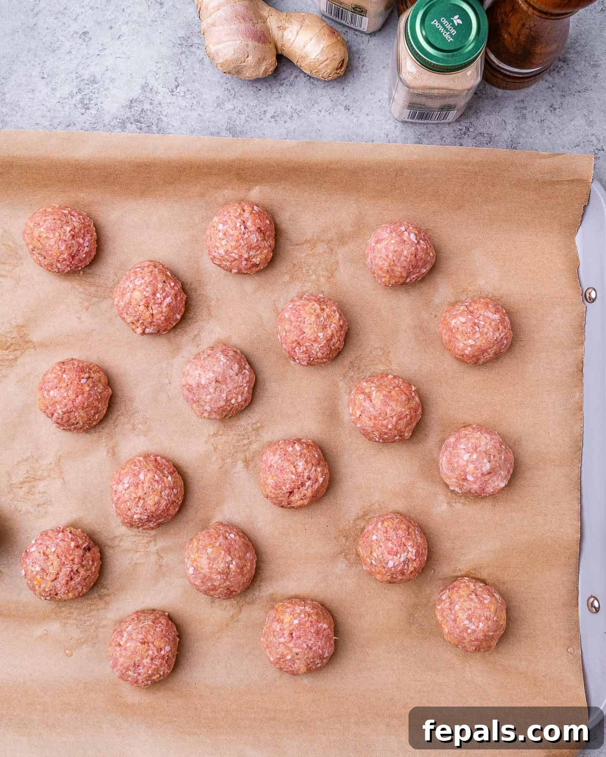 Sticky Teriyaki Turkey Meatballs 5 Raw, perfectly formed turkey meatballs arranged on a parchment-lined baking tray.