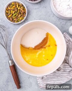 A mixing bowl with melted butter, granulated sugar, and vanilla extract before mixing.