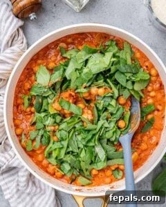 Fresh chopped spinach added into simmering chickpeas and sauce.