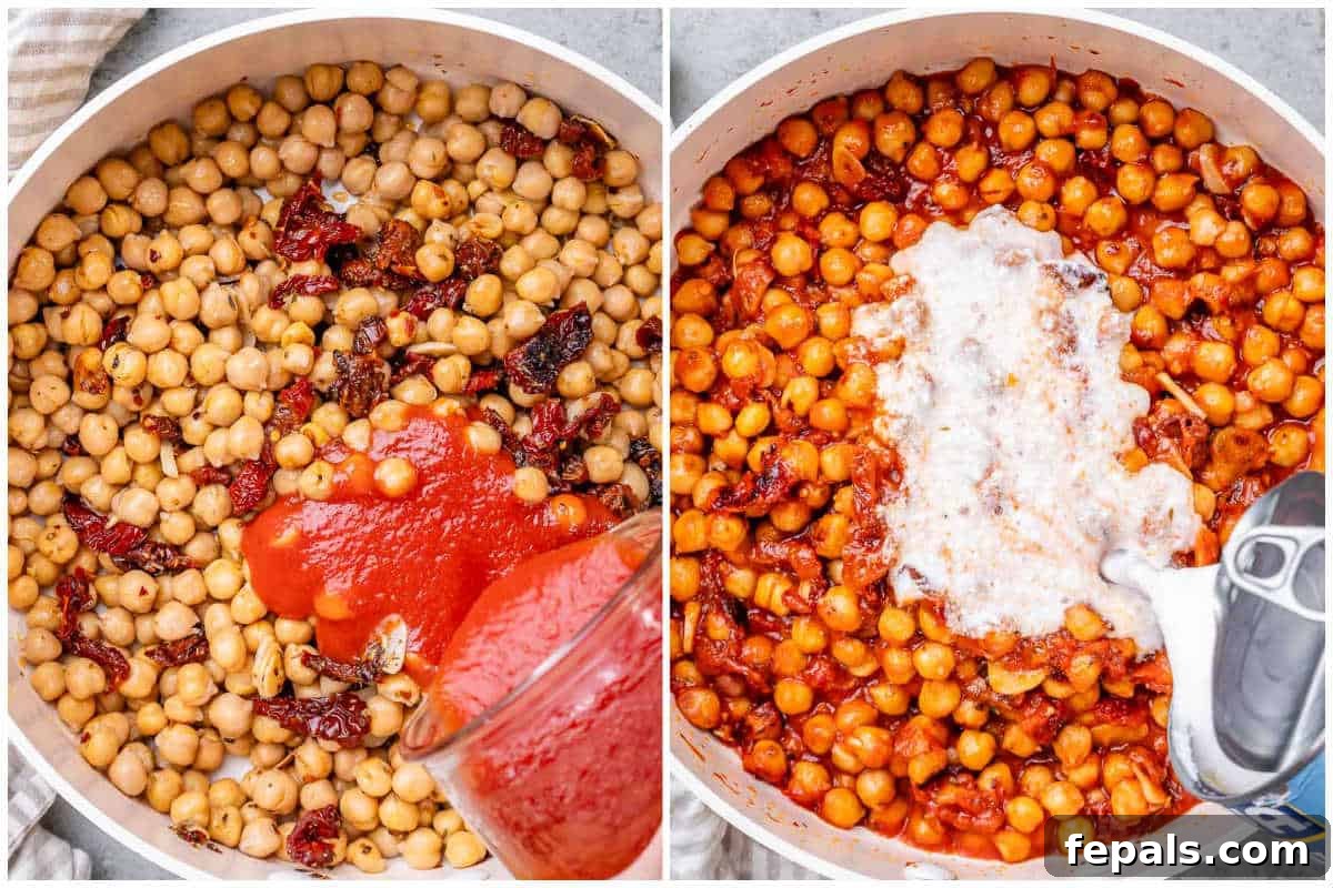 Process shot of pouring smooth tomato sauce over sautéed chickpeas, sun-dried tomatoes, and garlic in a skillet.