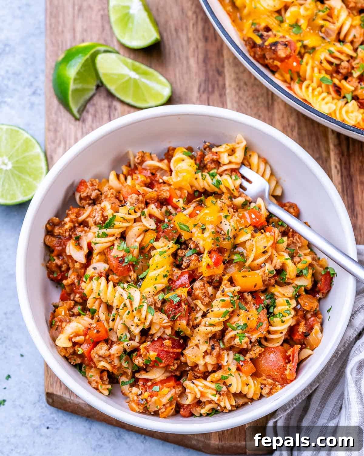 Comforting Ground Turkey Pasta 13 Portion of the cooked pasta served in a bowl, with lime wedges on the side for optional garnish.