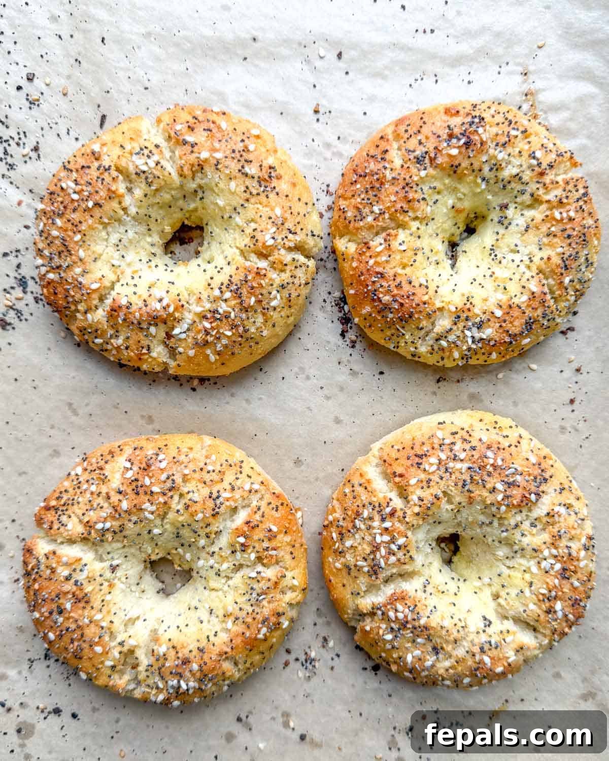 Low-Carb Almond Bagels 11 Four freshly baked, golden-brown almond flour bagels cooling on a sheet pan.