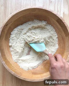 Low-Carb Almond Bagels 15 Spatula mixing the almond flour in a bowl.