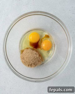 Eggs, sugar, and vanilla extract in a mixing bowl ready to be whisked for the brownie batter.
