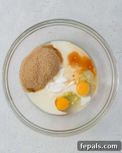 Wet ingredients and sugar added to a mixing bowl, ready to be whisked.