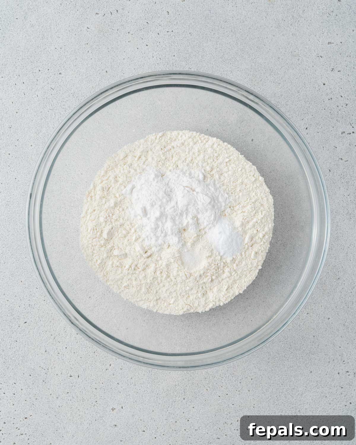 Bowl of dry ingredients including flour, baking powder, baking soda, and salt.