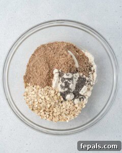 flax, oatmeal, and protein powder added over peanut butter in a bowl.