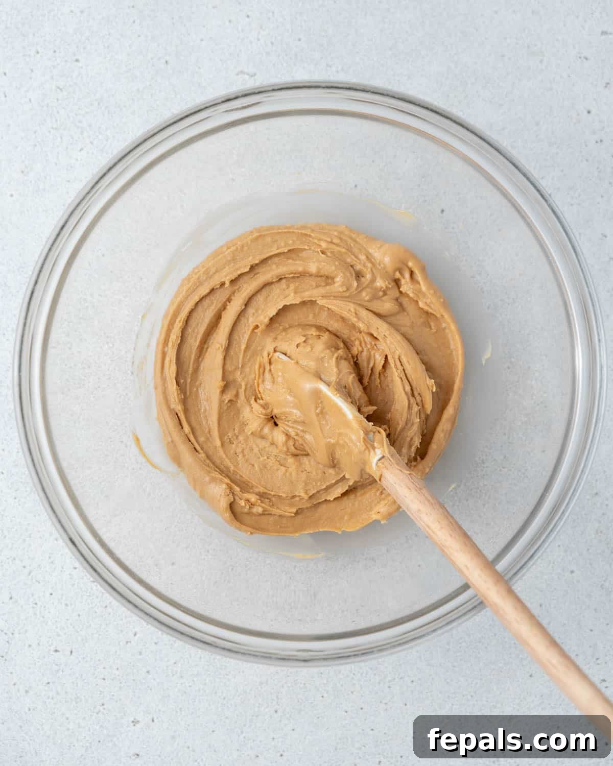 Peanut butter and honey being mixed together in a bowl.