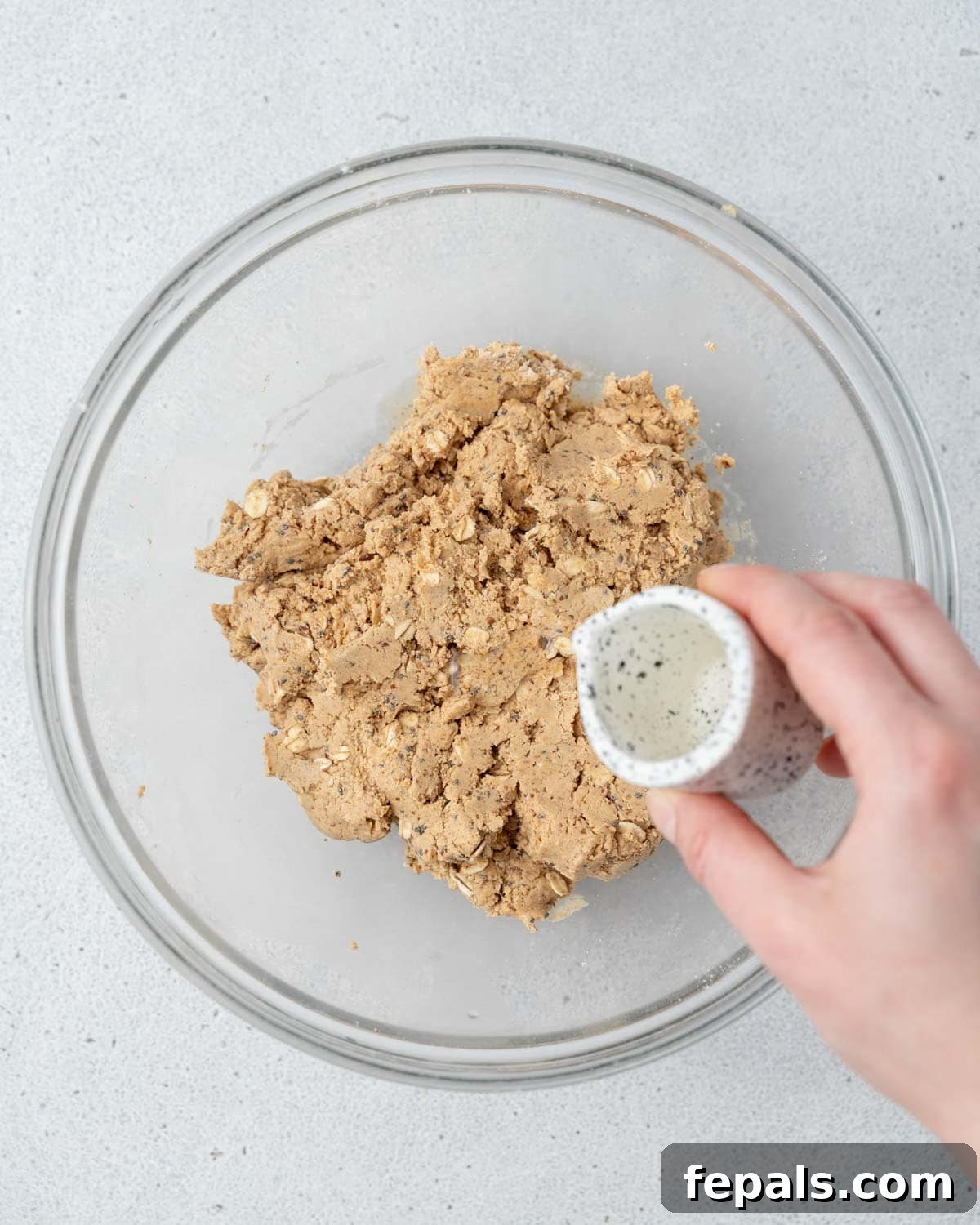 Water being added gradually over the peanut butter and oat mix.