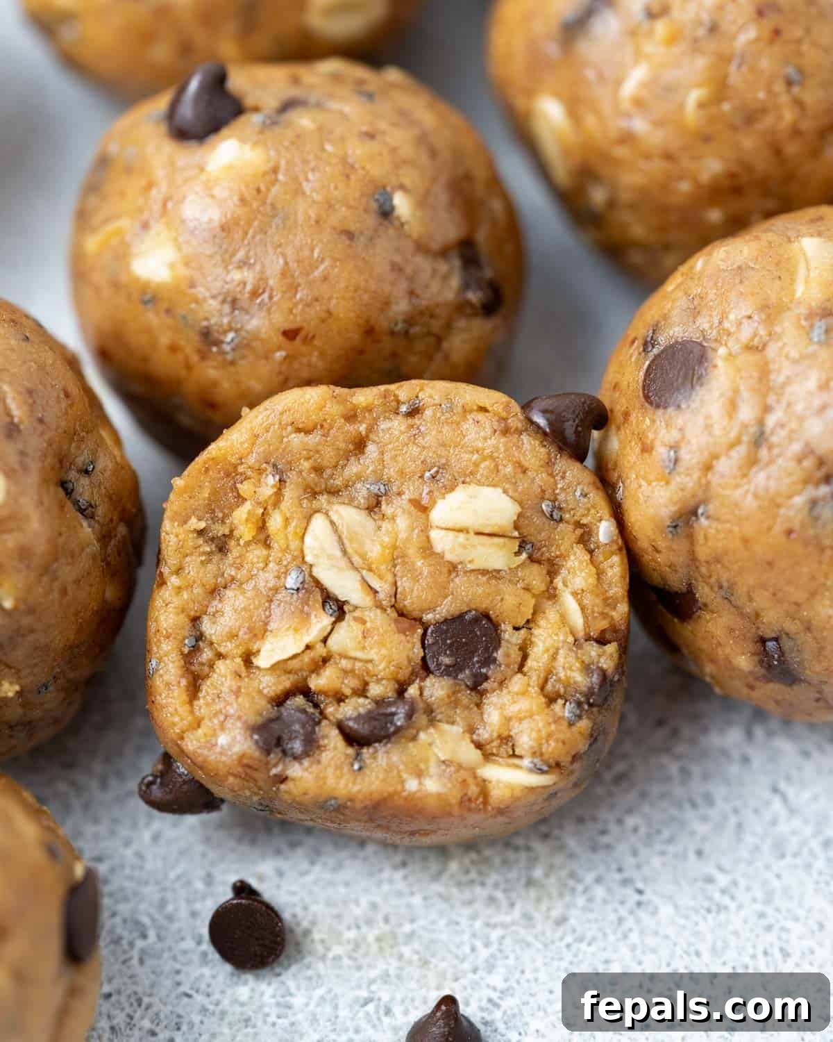 A peanut butter protein ball sliced in half, revealing its textured interior.