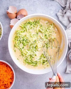 Moist Zucchini Carrot Loaf 10 Bowl of batter with freshly grated zucchini added, mid-stir with a whisk.