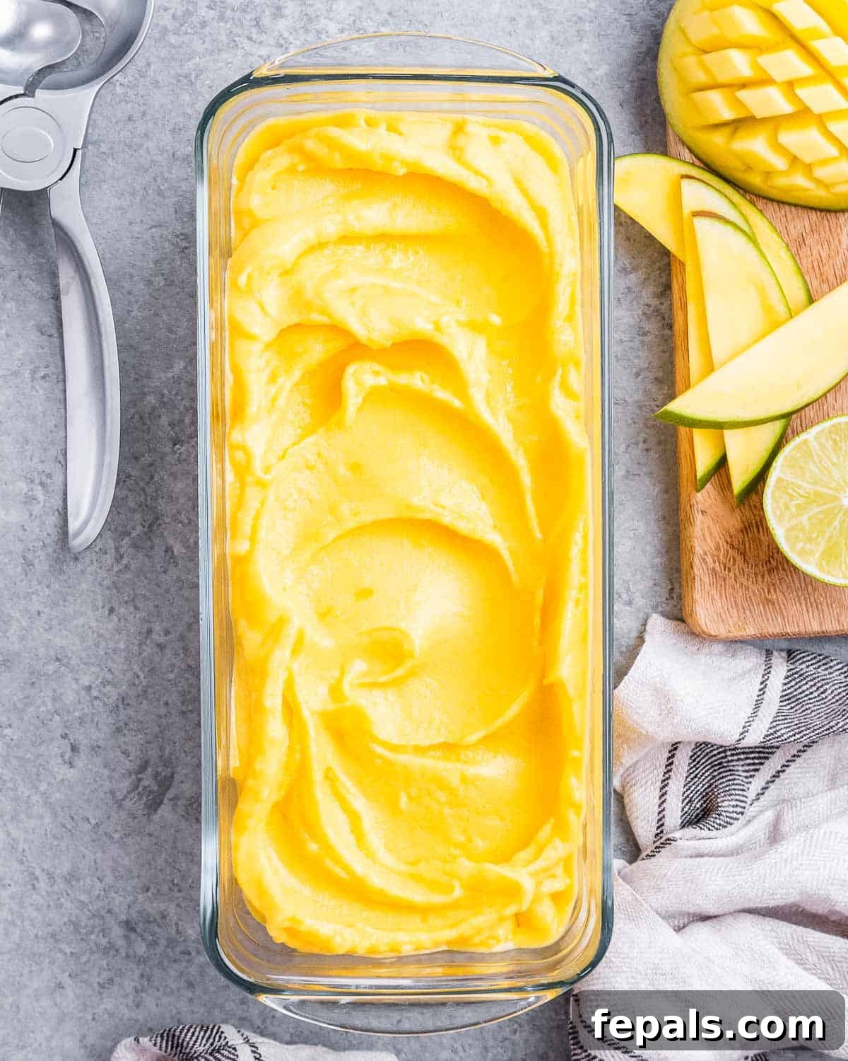 Tropical Mango Sorbet 11 A rectangular bowl with elegant scoops of homemade mango sorbet, garnished with a sprig of mint, ready to be served.