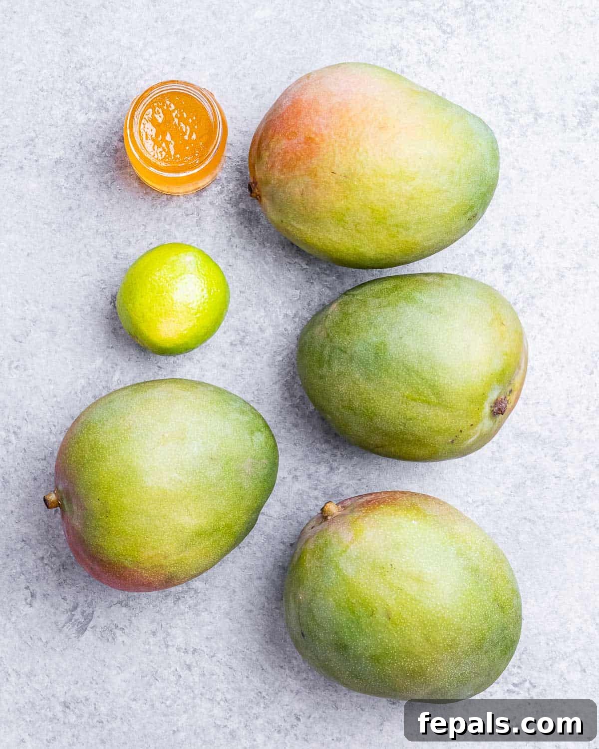 Tropical Mango Sorbet 3 A vibrant display of the three simple ingredients: fresh mangoes, a jar of golden honey, and bright green limes, highlighting the recipe's ease and natural goodness.