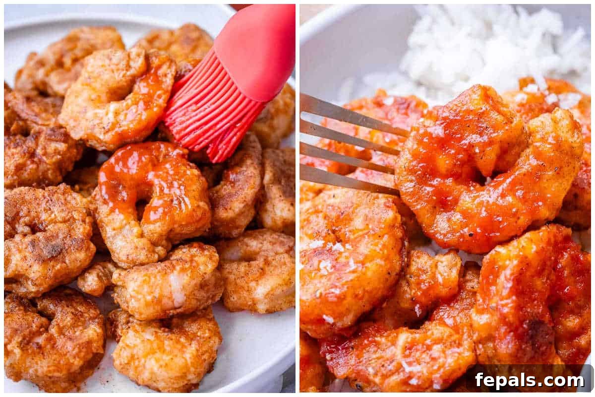 A process shot demonstrating basting the cooked shrimp with buffalo sauce and serving them in a bowl.