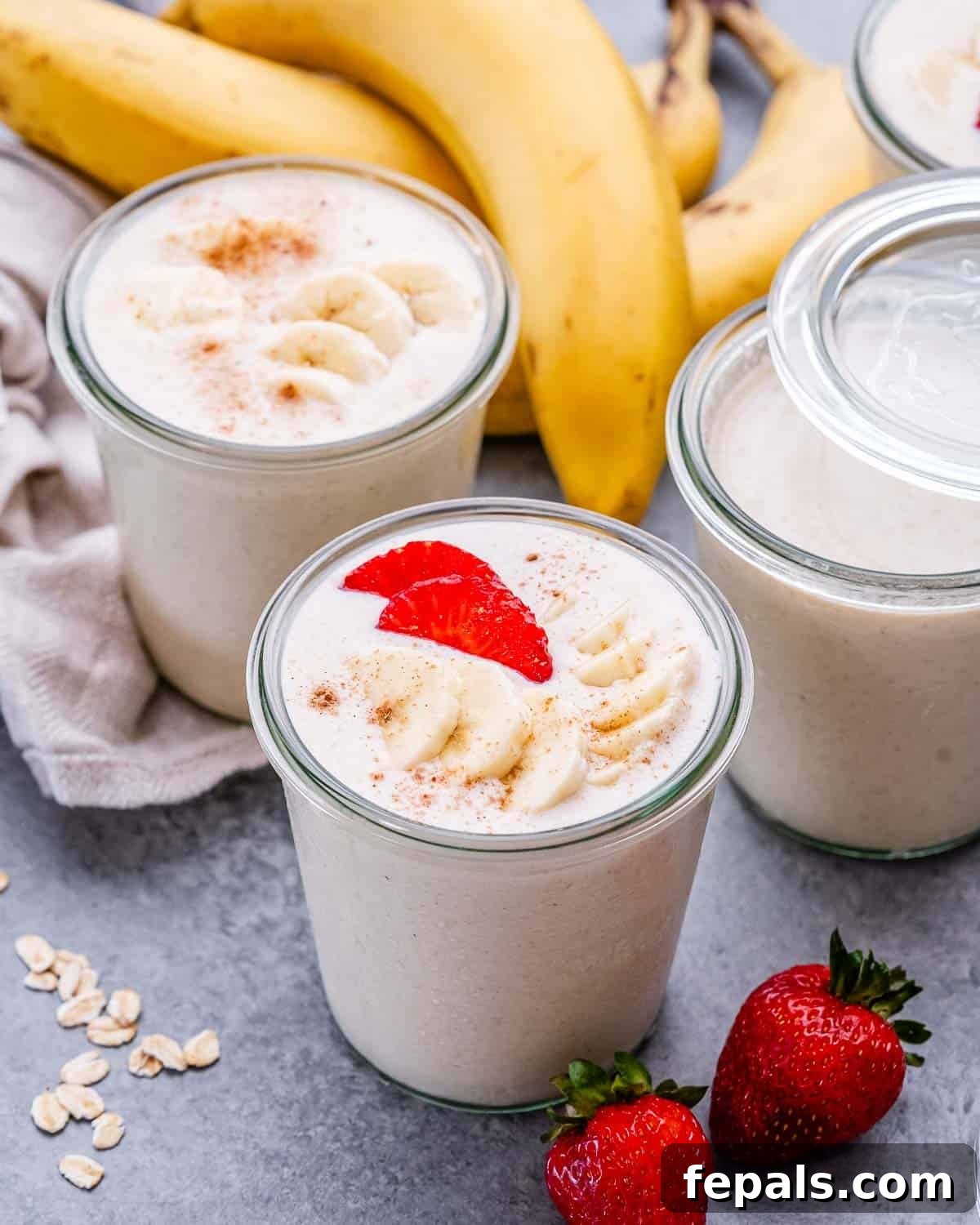 Smooth Overnight Oats 2 Jars of blended overnight oats topped with fresh banana and strawberries, ready for a healthy breakfast.