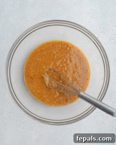 Sweet potato mixed with egg and oil in a bowl.