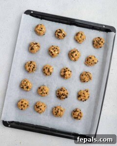 Sweet potato cookie dough scooped onto a parchment-lined baking sheet.