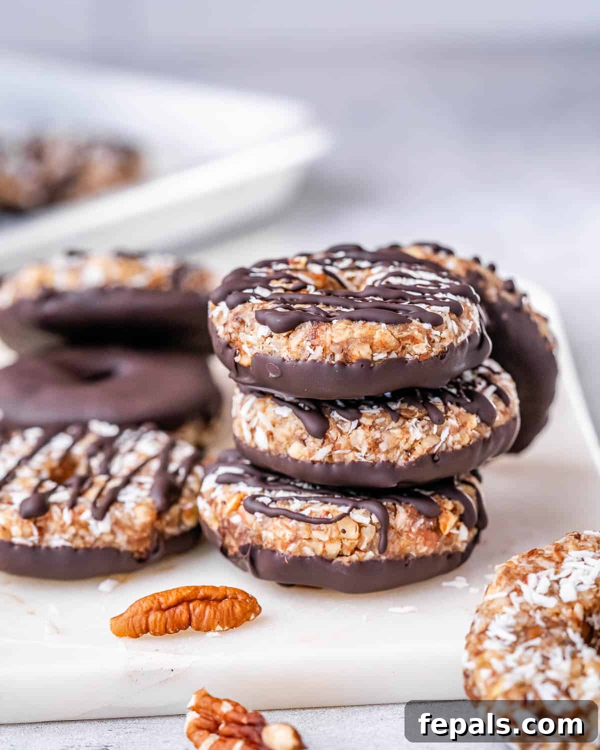 Three perfectly stacked, finished homemade Samoa cookies, showing off their layers.