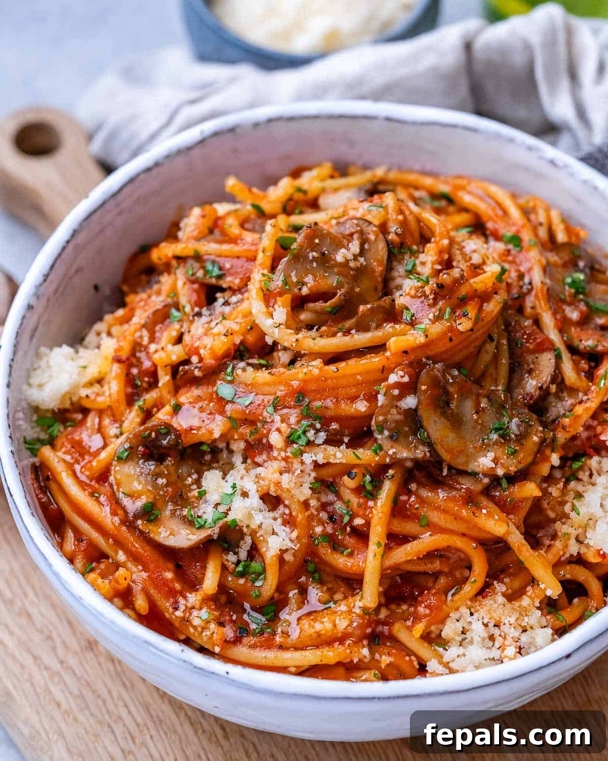 Effortless Instant Pot Spaghetti 2 A white bowl with Instant Pot Spaghetti garnished with Parmesan cheese and fresh parsley
