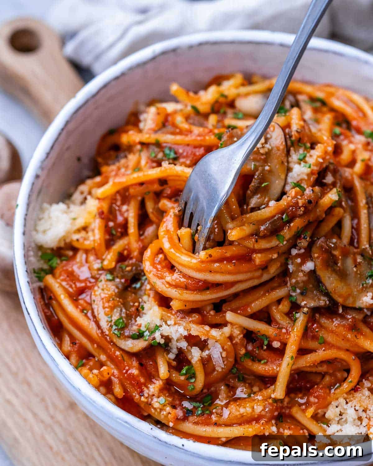 Effortless Instant Pot Spaghetti 14 A fork twirling in a white bowl of Instant Pot spaghetti, ready to eat.